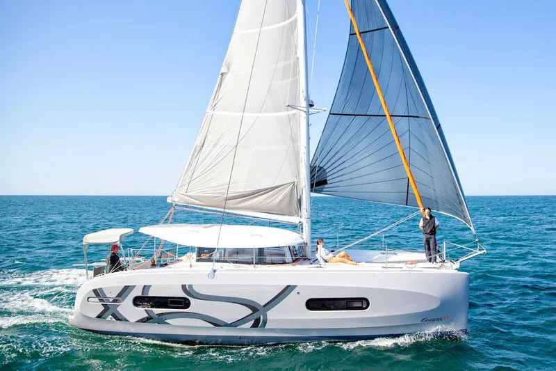 Slide: The Image of Manufacturer Provided Image: 2026 Excess 11 catamaran sailing on open sea with full sails. - 11