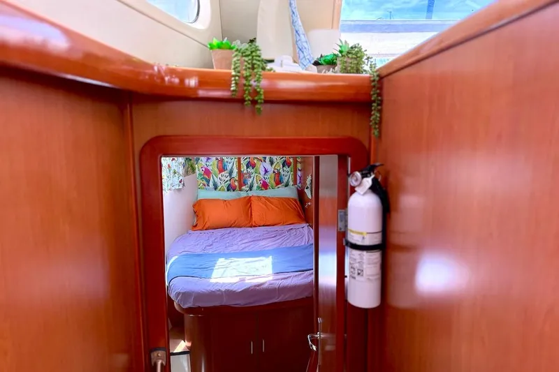Slide: The Image of Cozy cabin interior of 2010 Leopard 46 yacht with vibrant bedding and wooden finish. - 55