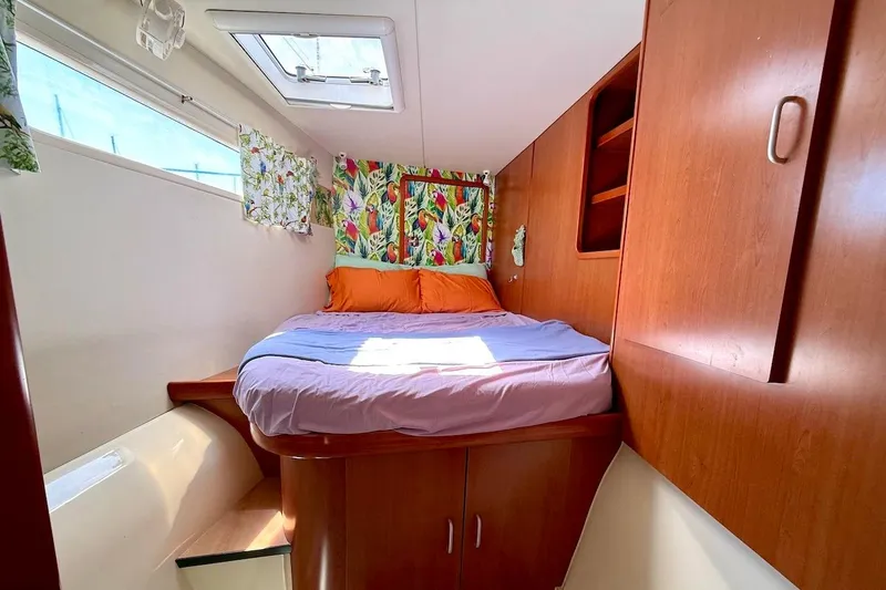 Slide: The Image of Cozy cabin interior of 2010 Leopard 46 yacht with colorful bedding and wooden cabinetry. - 56