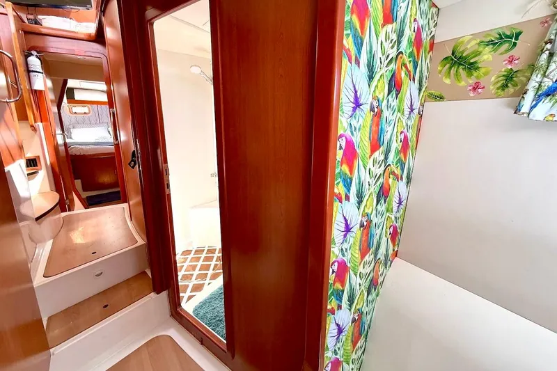 Slide: The Image of Interior of 2010 Leopard 46 yacht with vibrant parrot-themed decor and wooden finishes. - 58
