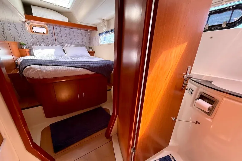 Slide: The Image of Cozy bedroom and bathroom interior of 2010 Leopard 46 yacht with wooden finishes. - 62