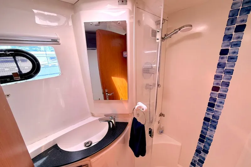 Slide: The Image of Modern yacht bathroom with shower, sink, and blue tile accents in a 2010 Leopard 46. - 65