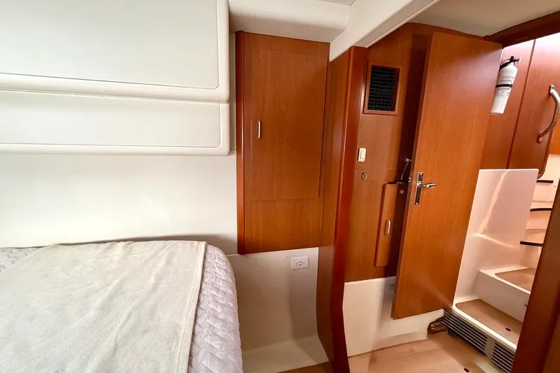 Slide: The Image of Interior of a 2010 Leopard 46 yacht cabin with wooden doors and cozy bedding. - 72