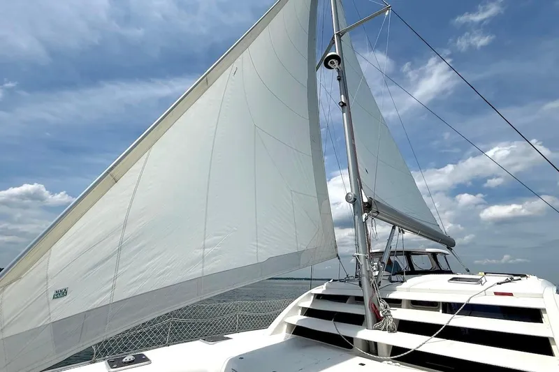 Slide: The Image of Sailing catamaran Leopard 46 from 2010 with white sails against a blue sky. - 8