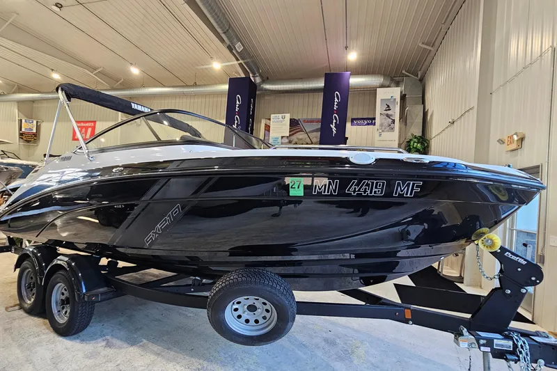 The Image of 2022 Yamaha Boats SX210 on trailer in indoor showroom setting. - 1
