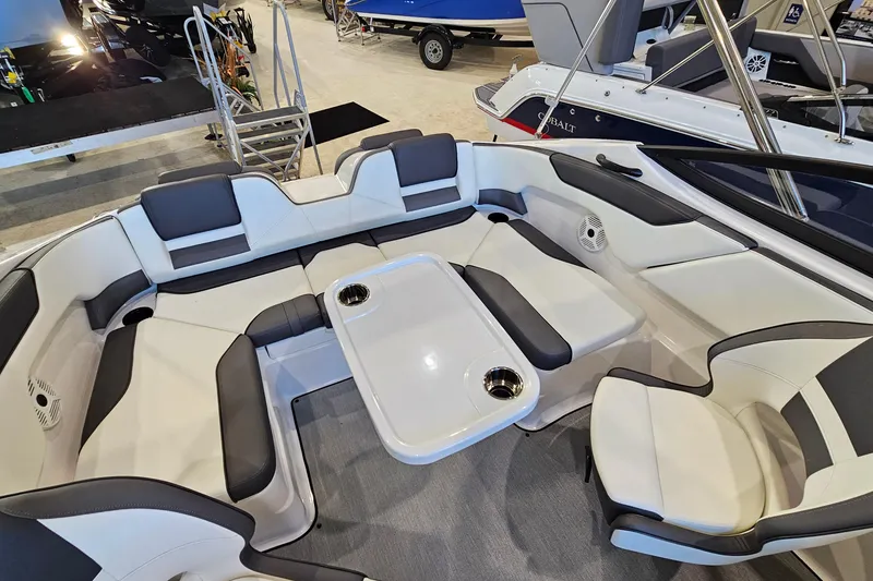 Slide: The Image of 2022 Yamaha Boats SX210 interior with spacious seating and table, showcasing modern design. - 21