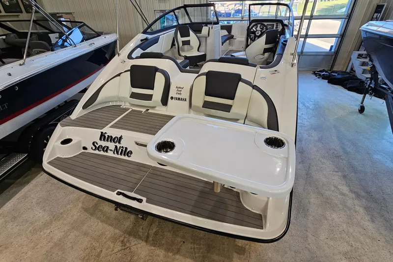 Slide: The Image of 2022 Yamaha Boats SX210 with seating and table, displayed indoors. - 22