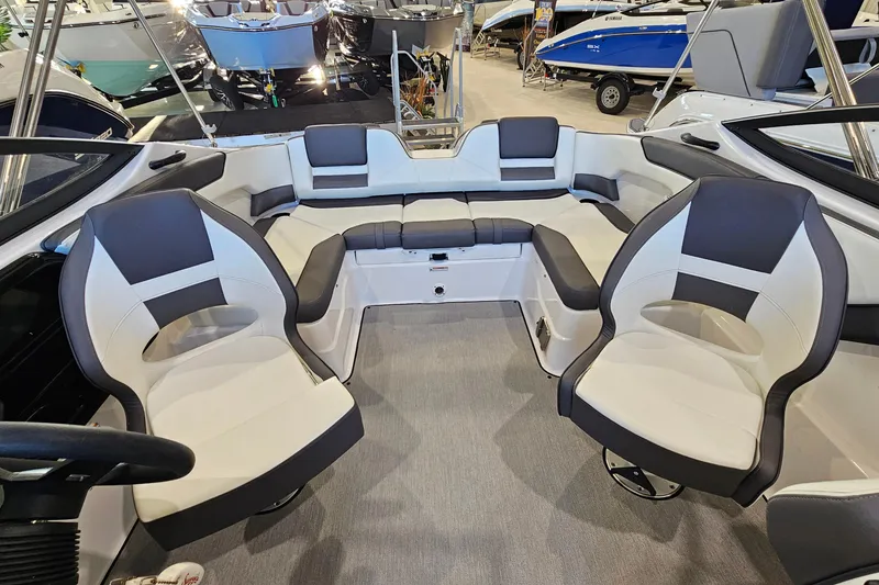 Slide: The Image of 2022 Yamaha Boats SX210 interior with modern seating and sleek design in showroom. - 7