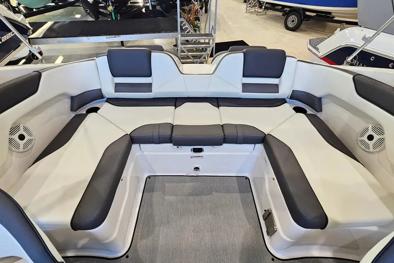 Slide: The Image of 2022 Yamaha Boats SX210 interior seating with gray and white upholstery, showcasing spacious design. - 8