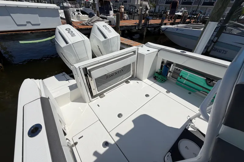 Slide: The Image of 2019 Blackfin 242 CC boat with twin outboard engines docked at marina. - 12