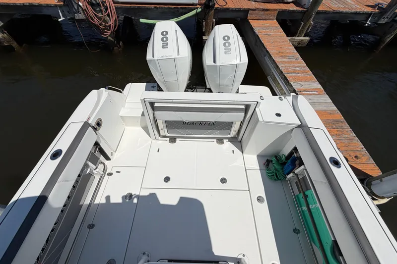 Slide: The Image of 2019 Blackfin 242 CC boat with twin engines docked at a marina. - 13