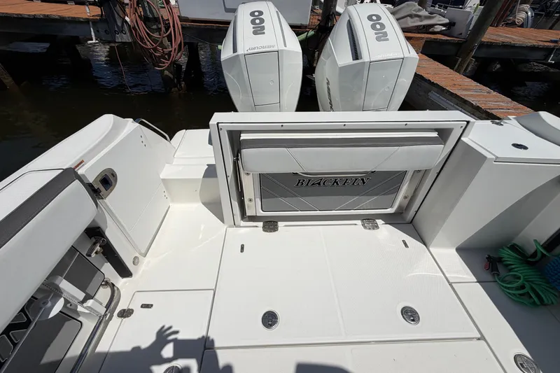 Slide: The Image of 2019 Blackfin 242 CC boat deck with dual outboard engines at dock. - 14