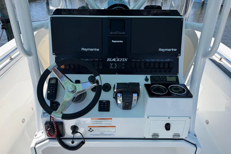 Slide: The Image of 2019 Blackfin 242 CC boat dashboard with Raymarine electronics and steering wheel. - 16