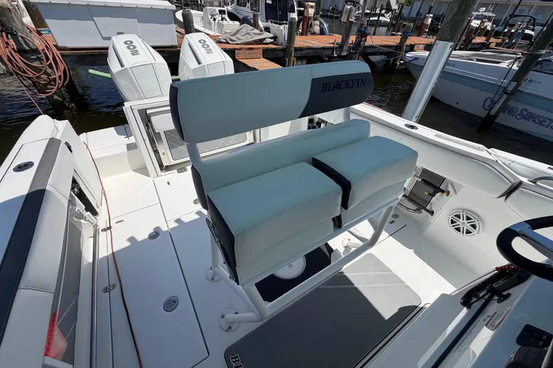 Slide: The Image of 2019 Blackfin 242 CC boat interior with dual seats and twin outboard engines. - 18