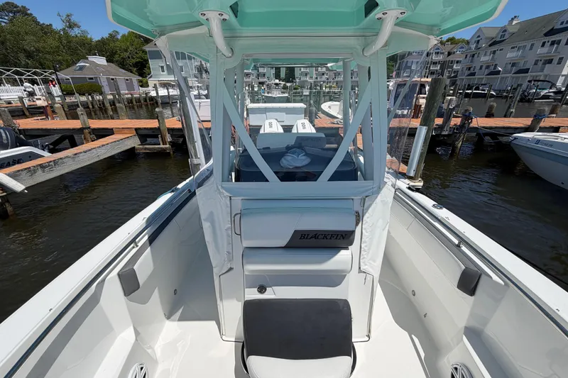 Slide: The Image of 2019 Blackfin 242 CC boat docked at marina, showcasing sleek design and spacious deck. - 21