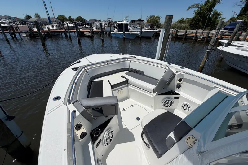 Slide: The Image of 2019 Blackfin 242 CC boat interior at marina, featuring seating and speakers. - 23