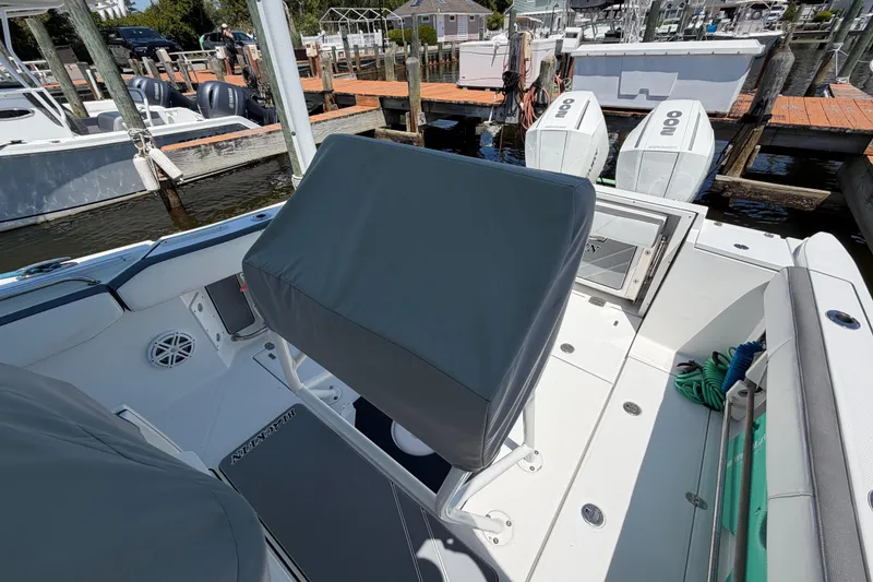 Slide: The Image of 2019 Blackfin 242 CC boat interior with covered seating and twin outboard engines at a dock. - 35