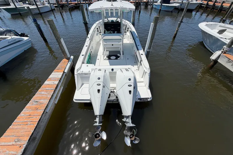 Slide: The Image of 2019 Blackfin 242 CC boat docked with dual outboard engines in a marina. - 7