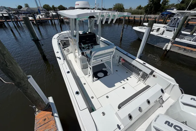 Slide: The Image of 2019 Blackfin 242 CC boat docked at marina, featuring spacious deck and modern controls. - 9