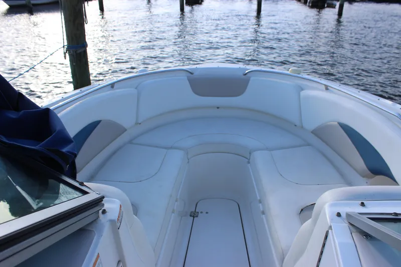 Slide: The Image of 2007 Chaparral 276 SSX boat interior with white seating, docked by the water. - 12