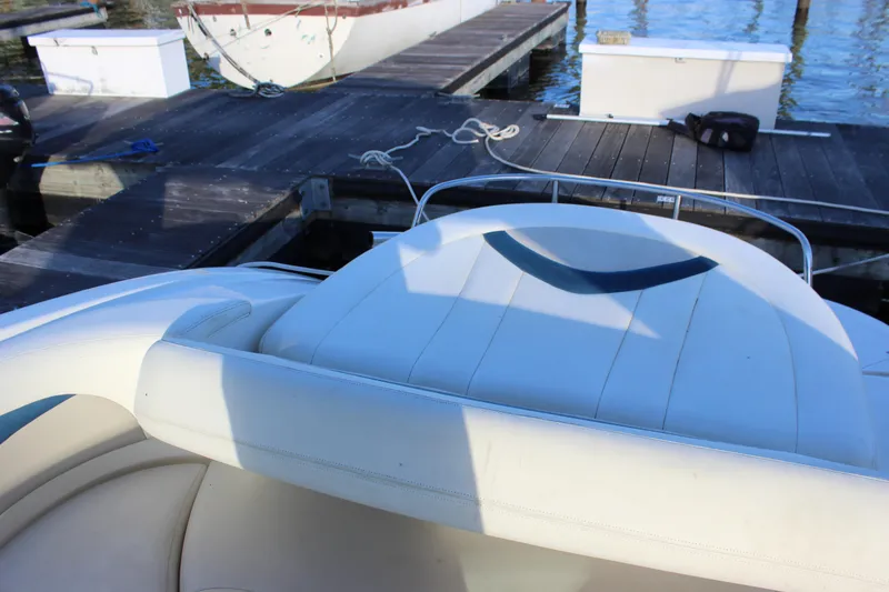 Slide: The Image of 2007 Chaparral 276 SSX boat interior at dock, featuring white seating and calm waters. - 19