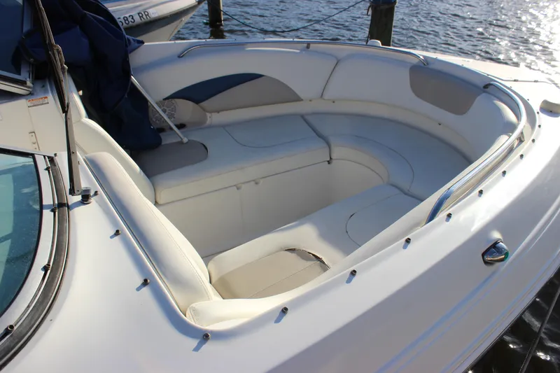 Slide: The Image of 2007 Chaparral 276 SSX boat with spacious white seating area, docked by the water. - 28