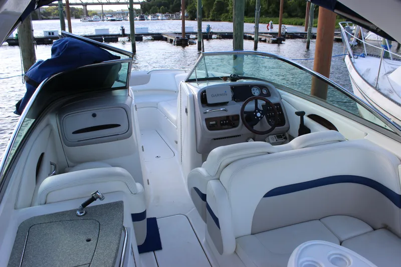 Slide: The Image of 2007 Chaparral 276 SSX boat interior with steering wheel and seating, docked by the water. - 9