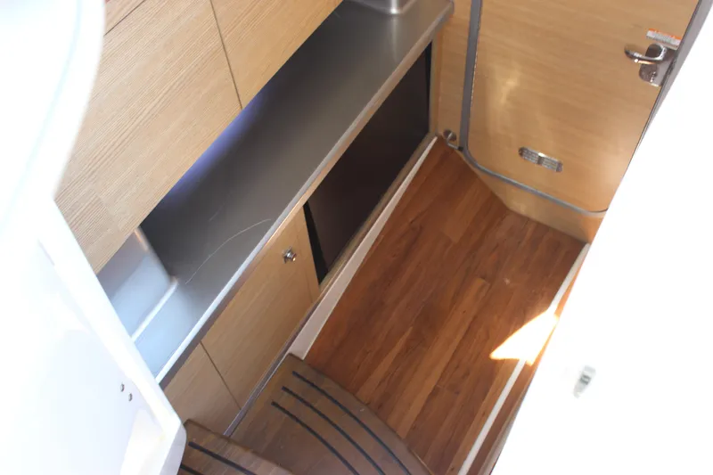 Slide: The Image of Interior of 2012 Chaparral 327 SSX boat with wood flooring and sleek cabinetry. - 14