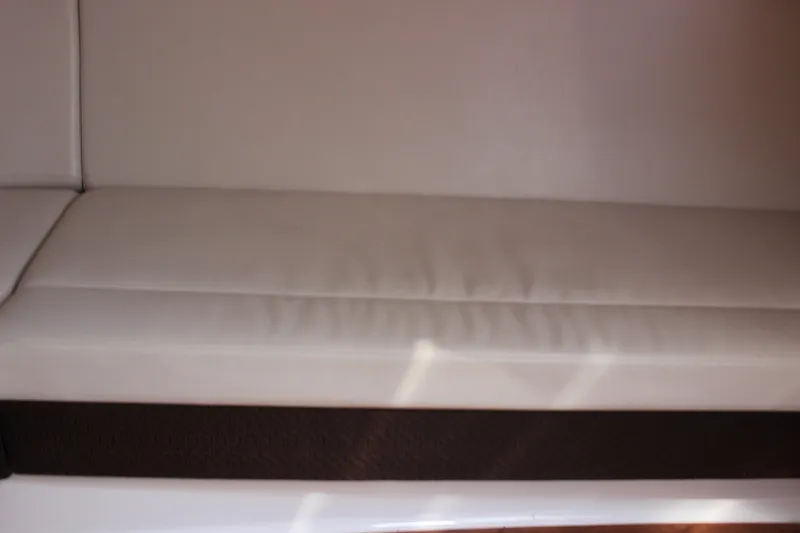 Slide: The Image of White leather seating on a 2012 Chaparral 327 SSX boat interior. - 16
