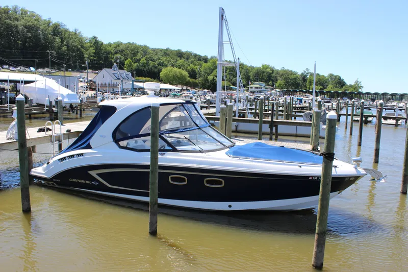 Slide: The Image of 2012 Chaparral 327 SSX boat docked at a marina on a sunny day. - 2