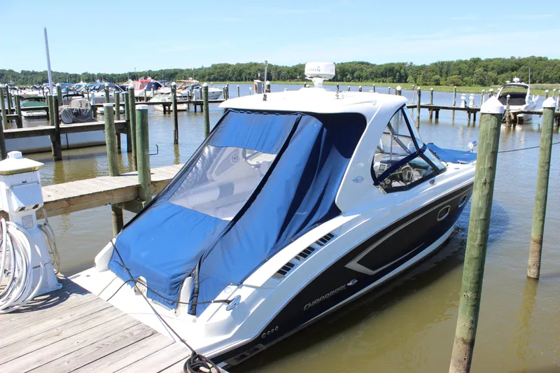 Slide: The Image of 2012 Chaparral 327 SSX boat docked at a marina with blue canopy. - 3