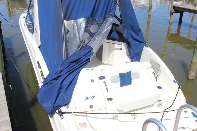 Slide: The Image of 2012 Chaparral 327 SSX boat with blue cover docked at marina. - 33