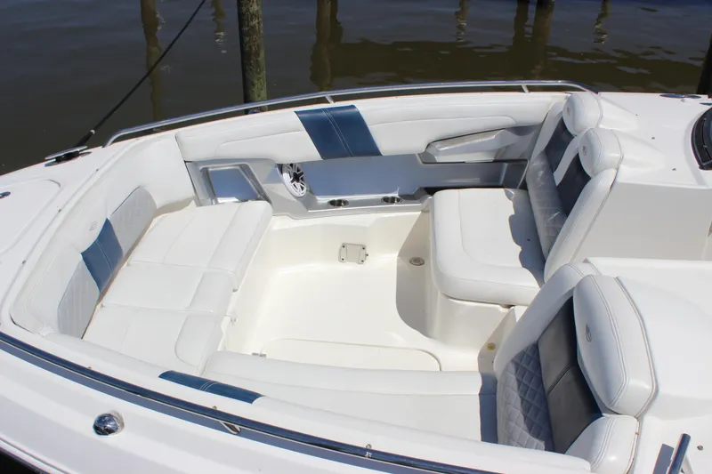 Slide: The Image of 2012 Chaparral 327 SSX boat interior with white and blue seating, docked by water. - 34