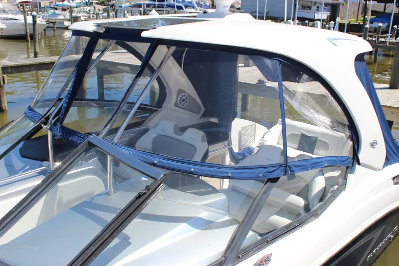 Slide: The Image of 2012 Chaparral 327 SSX boat with blue canopy docked at marina. - 35