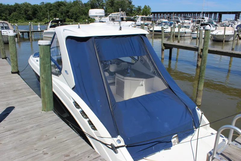Slide: The Image of 2012 Chaparral 327 SSX boat docked with blue cover, marina background. - 4