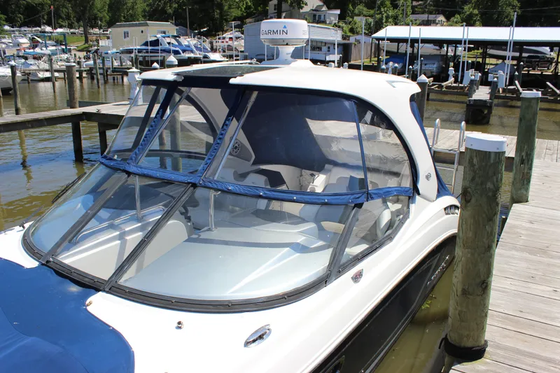 Slide: The Image of 2012 Chaparral 327 SSX boat docked at a marina with clear canopy. - 5