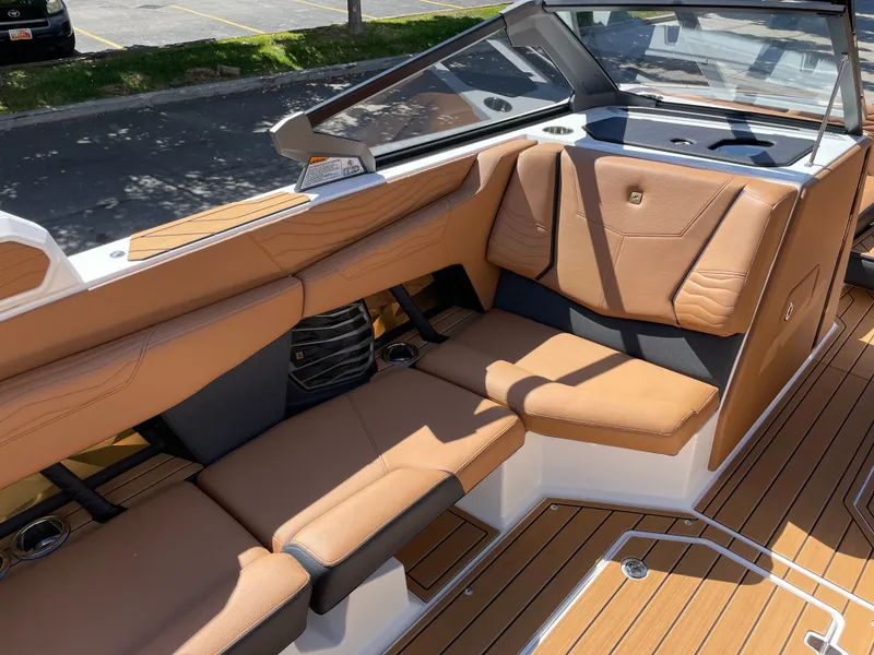 Slide: The Image of 2025 Nautique G23 interior with brown leather seating. - 10