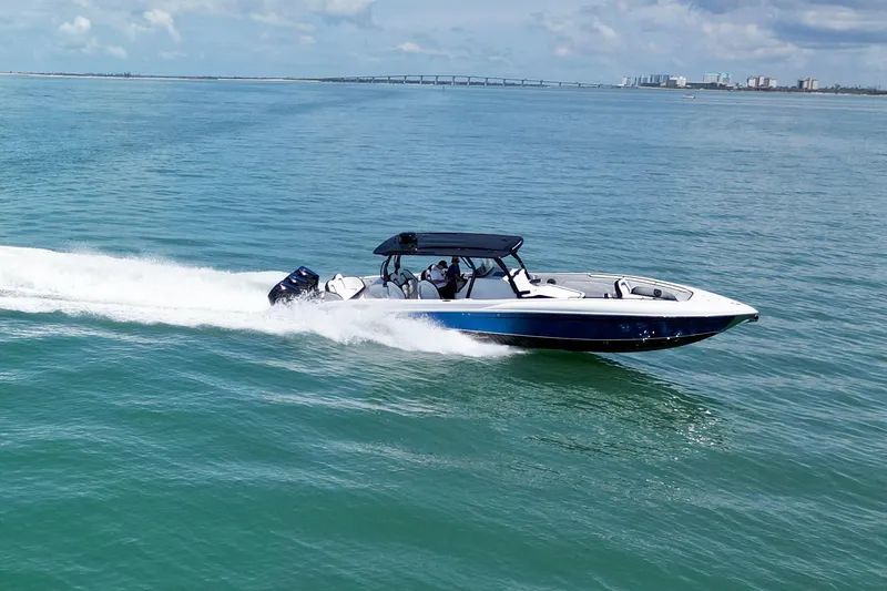 Slide: The Image of 2024 Renegade 38 Open boat cruising on clear blue water under a sunny sky. - 10