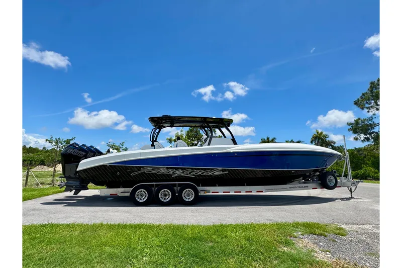 Slide: The Image of 2024 Renegade 38 Open boat on trailer, sleek design under clear blue sky. - 12