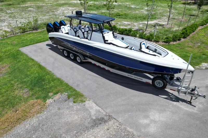 Slide: The Image of 2024 Renegade 38 Open boat on trailer, sleek design, parked on paved driveway. - 14