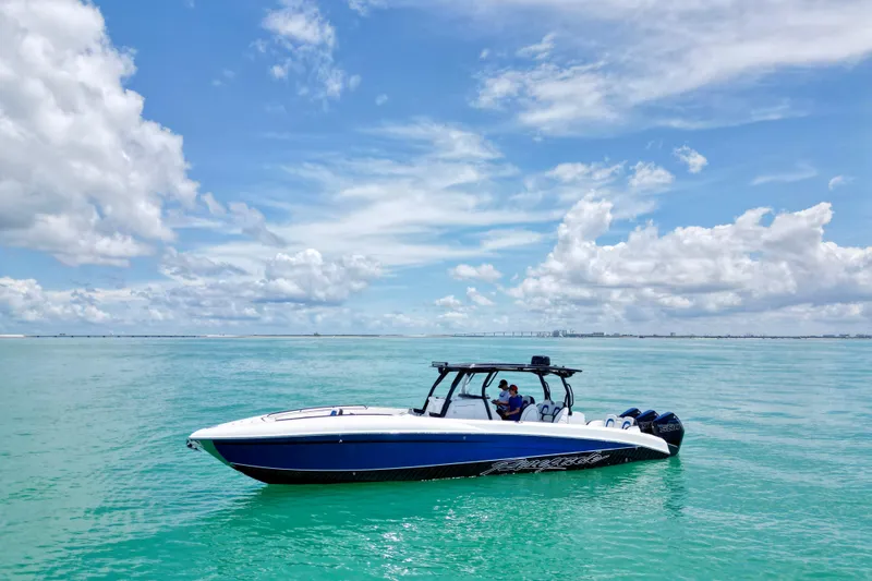 Slide: The Image of 2024 Renegade 38 Open boat cruising on turquoise waters under a clear blue sky. - 2