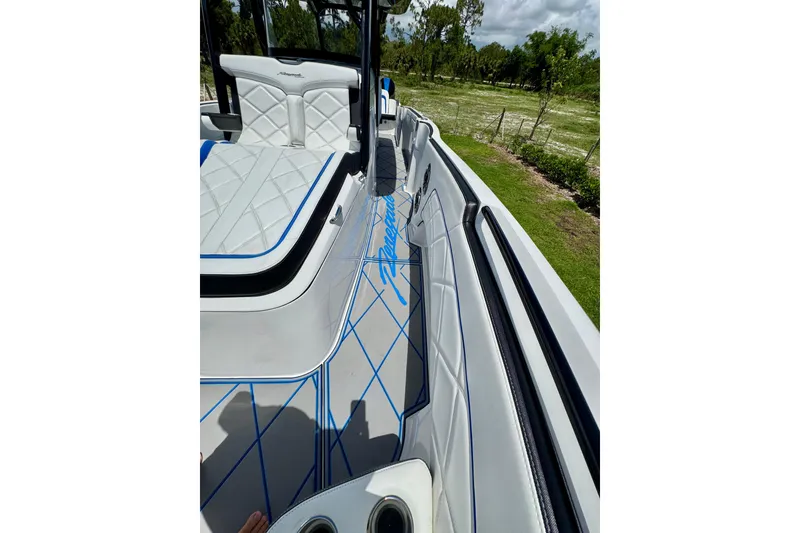 Slide: The Image of 2024 Renegade 38 Open boat interior with white and blue seating, sleek design. - 39