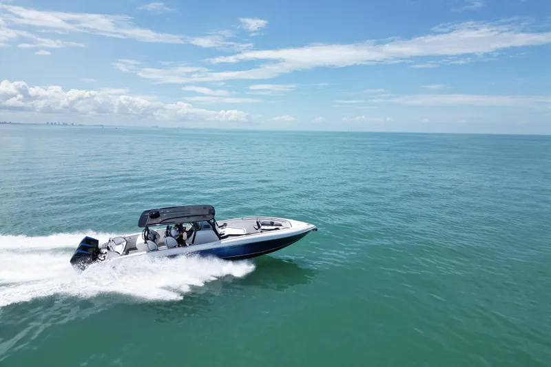 Slide: The Image of 2024 Renegade 38 Open boat cruising on clear blue ocean under a sunny sky. - 5