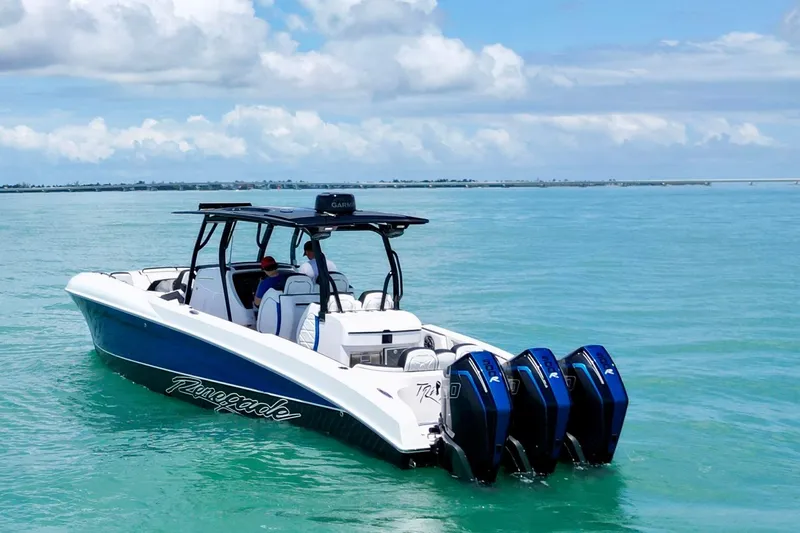 Slide: The Image of 2024 Renegade 38 Open boat cruising on clear blue water under a partly cloudy sky. - 7