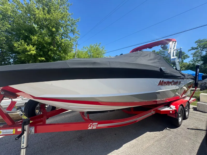 The Image of 2017 MasterCraft XT23 boat with cover on trailer. - 1