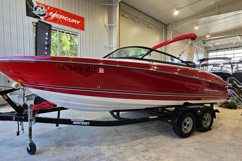The Image of Red 2021 Monterey 224FS boat on trailer in indoor showroom setting. - 1