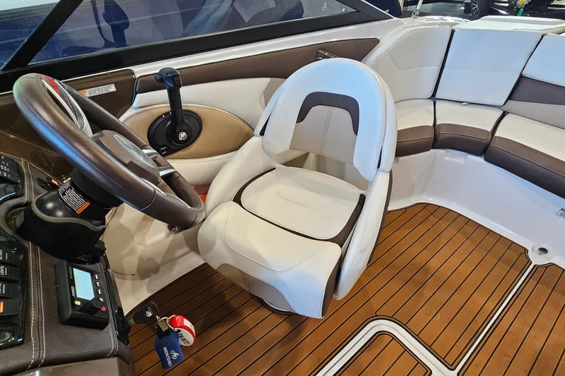Slide: The Image of 2021 Monterey 224FS boat interior with steering wheel, seating, and wood flooring. - 11