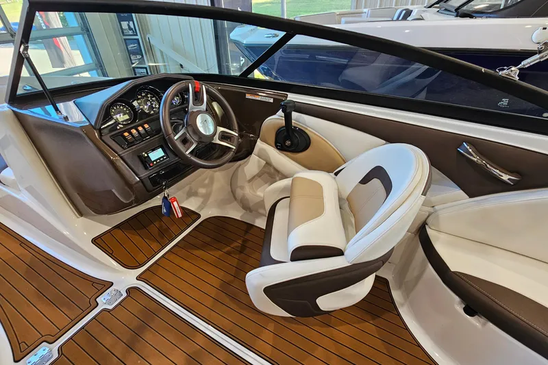 Slide: The Image of 2021 Monterey 224FS boat interior with steering wheel and seating, featuring wood-style flooring. - 12