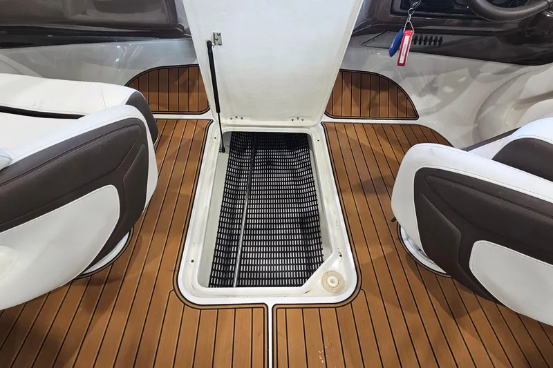 Slide: The Image of 2021 Monterey 224FS boat interior with open storage compartment and teak flooring. - 22