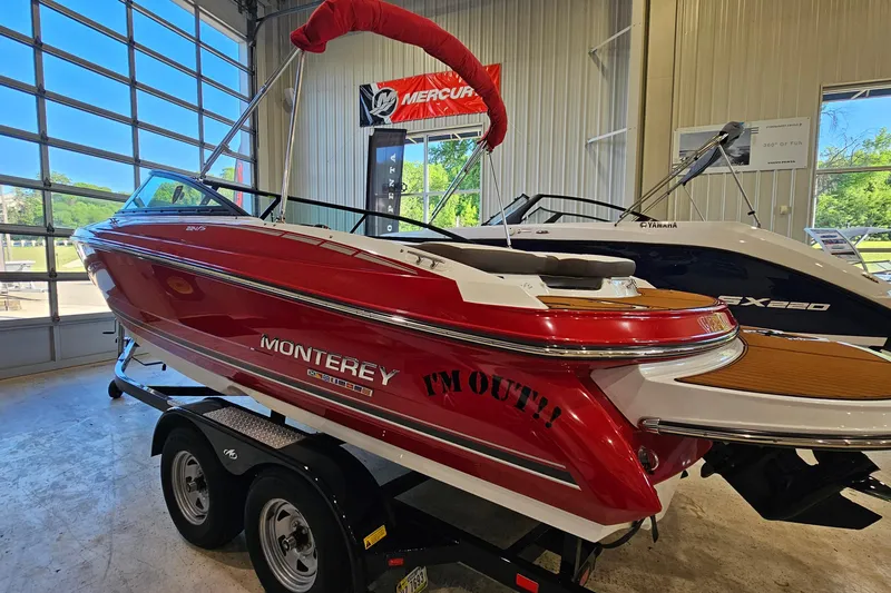 Slide: The Image of 2021 Monterey 224FS boat in showroom, red exterior, on trailer, indoor display. - 4